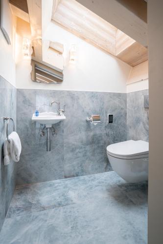 a bathroom with a toilet and a sink at Mirabeau Etoile in Zermatt