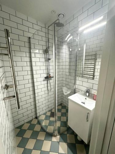 La salle de bains blanche est pourvue d'un lavabo et d'une douche. dans l'établissement Luxurios And Stunningly Beatiful, à Göteborg