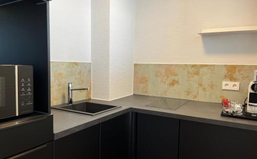 a kitchen with a sink and a microwave at Hotel Schlossberg in Badenweiler