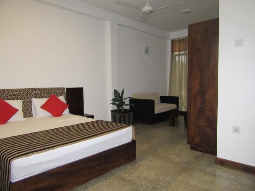 YatiyantotaにあるMiridiya Resortのベッドと椅子付きのホテルルーム