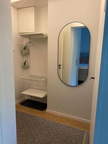 a room with a mirror and a closet with shelves at Modern apartment with parking in Helsinki