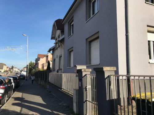 eine Person, die eine Straße entlang geht, neben einem Haus in der Unterkunft Appartement à la découverte de Strasbourg in Bischheim