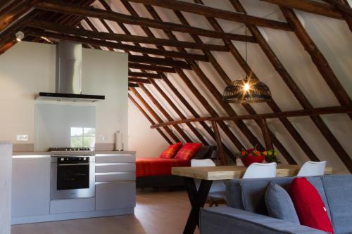 a kitchen and a living room with a couch and a table at Appartement Badnieuweschans in Bad-Nieuweschans