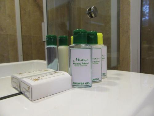 three bottles of soap and a box on a bathroom counter at Miridiya Resort in Yatiyantota