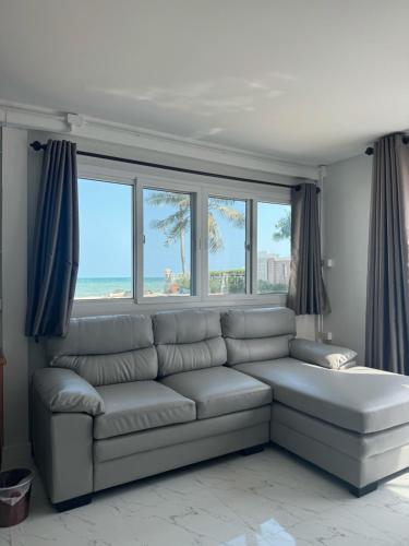 a living room with a couch and some windows at Pinsuk house Huahin บ้านปิ่นสุข หัวหิน ชะอำ in Phetchaburi