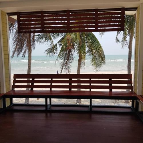 a bench in a room with a view of the beach at Pinsuk house Huahin บ้านปิ่นสุข หัวหิน ชะอำ in Phetchaburi
