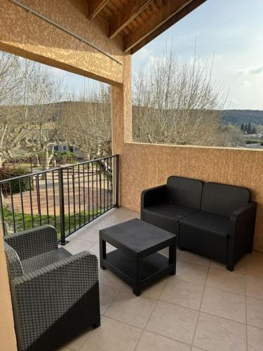 une terrasse avec deux chaises, un canapé et une table dans l'établissement Appartement tout équipé, à Les Granges-Gontardes