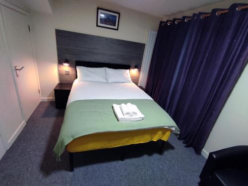 ein Schlafzimmer mit einem Bett mit zwei Handtüchern darauf in der Unterkunft Osney Hazel Studio - Self Contained Studio Flat in Oxford