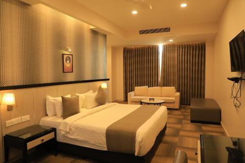 een hotelkamer met een bed en een woonkamer bij RAS Hotels in Kumbakonam