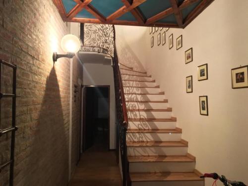 uma escada num quarto com uma luz e uma parede de tijolos em Stella De' Tolomei em Ferrara
