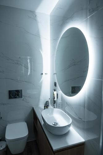 a white bathroom with a sink and a mirror at Volos Inn Hotel in Volos