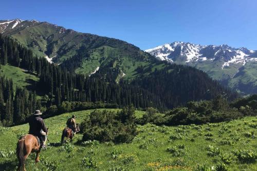 2 personnes à cheval dans un champ de montagnes dans l'établissement кайынды, à Acha-Kayyngdy