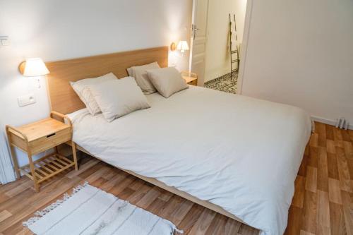 迪南的住宿－Appartement tout confort au centre ville de DINANT，铺有木地板的客房内一张大白色的床