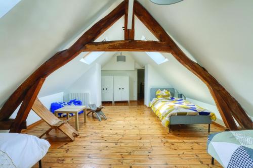 1 dormitorio en el ático con 1 cama y 1 mesa en Plénitude du Vexin - Grand jardin - 7 personnes, en Chaumont-en-Vexin