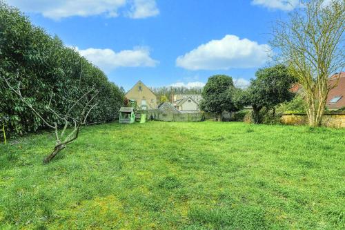 a field of green grass with houses in the background at Plénitude du Vexin - Grand jardin - 7 personnes in Chaumont-en-Vexin