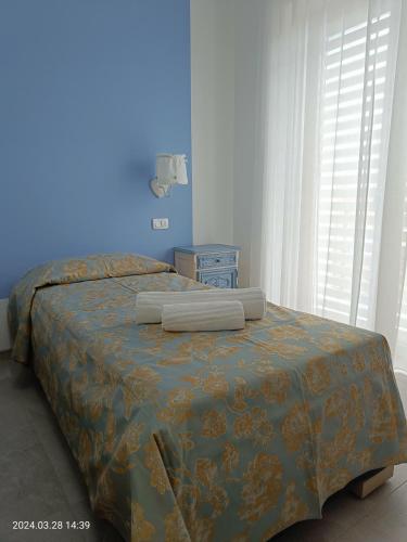 a bedroom with a bed with a blue wall at Villa Mariana Bed and Breakfast in Saluzzo