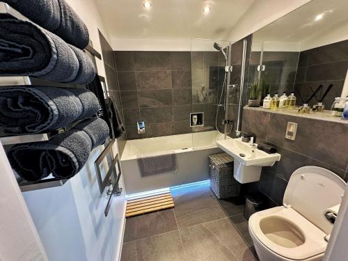 a bathroom with a toilet and a sink and a tub at Stunning Luxury 3 Bed Penthouse Sleeps 2 to 6 in Hythe