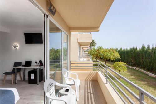 a room with a balcony with a table and chairs at Hospedium Hotel Abril in San Juan de Alicante