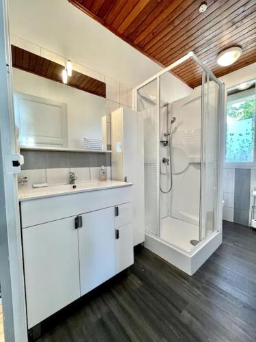 une salle de bain blanche avec une douche et un lavabo dans l'établissement Maison Famille 300m de l'océan, à Mimizan