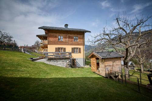 a large wooden house on the side of a hill at Miller Appartements in Sankt Veit im Pongau
