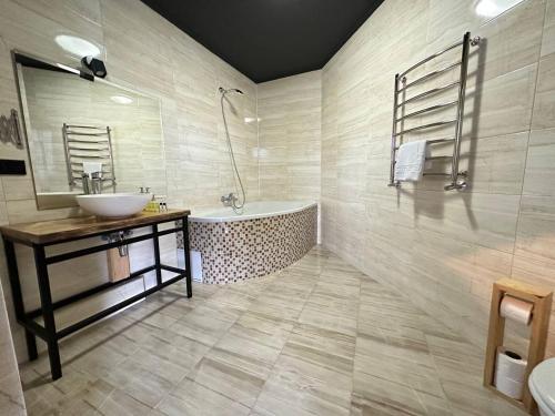 a bathroom with a tub and a sink and a bath tub at SPA HOTEL Gora in Bukovel
