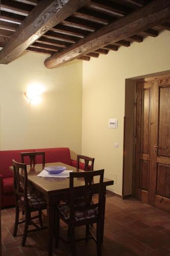 a dining room with a table and chairs and a red couch at Agriturismo Vallesessanta in Grotte di Castro