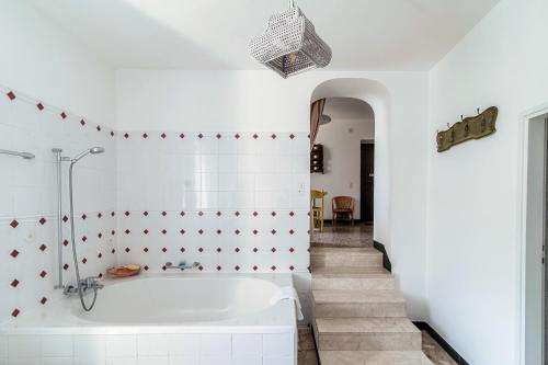 a white bathroom with a tub and a staircase at The Lake House by Quokka 360 - Lake view in Gandria village in Lugano