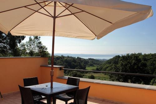 a table and chairs with an umbrella on a balcony at Agriturismo Vallesessanta in Grotte di Castro