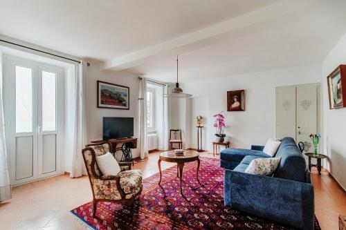 a living room with a blue couch and a table at The Lake House by Quokka 360 - Lake view in Gandria village in Lugano
