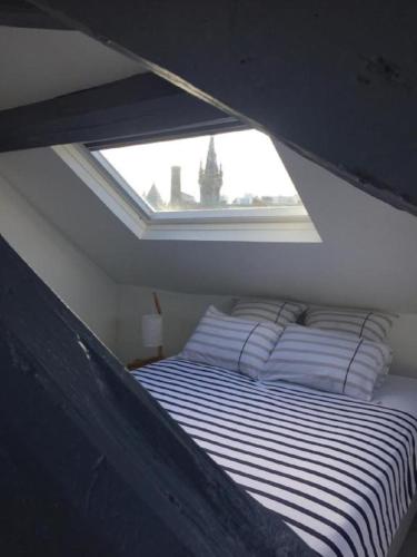un lit dans une petite pièce avec une fenêtre dans l'établissement Appartement à Fécamp avec vue port et mer Le Sémaphore, à Fécamp