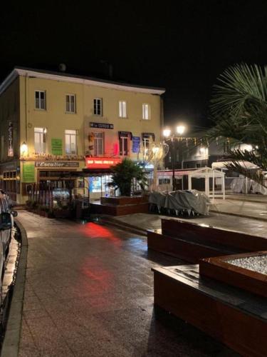 une rue de la ville avec des bâtiments et des arbres la nuit dans l'établissement Appartement à Fécamp avec vue port et mer Le Sémaphore, à Fécamp