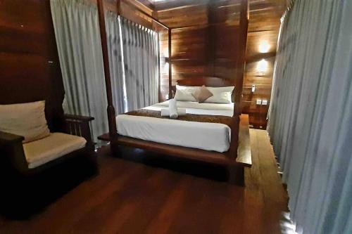 1 dormitorio con 2 camas y ventana en Umaduran Wooden Hut, en Silebeng