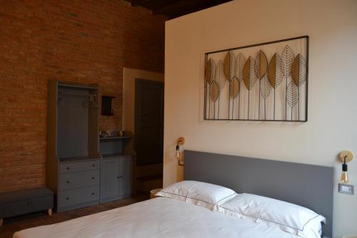a bedroom with a bed and a painting on the wall at Pagum Place in Torrita di Siena