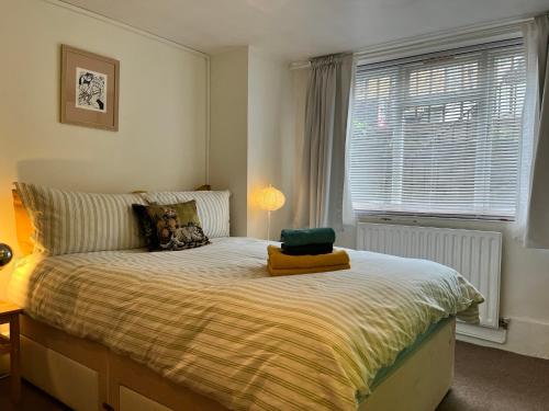 a bedroom with a large bed with a window at Comfy child/dog friendly garden flat heart Camden in London