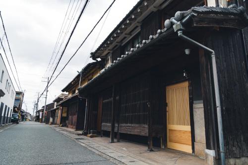 an empty street in an asian city with buildings at Johns House じょんのやど in Himeji