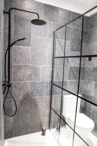 baño con ducha y puerta de cristal en Chambre avec SDB incroyable en plein centre-ville DINANT, en Dinant