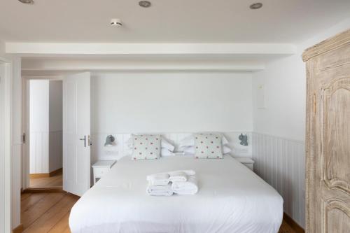 a bedroom with a white bed with towels on it at Stag Cottage, Sea wall in Whitstable