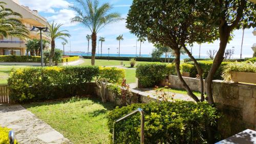 a park with palm trees and a building at Marítim II Primera línea de mar en St Antoni de Calonge in Sant Antoni de Calonge