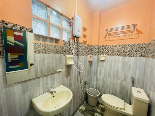 y baño con aseo y lavamanos. en Cozy 1BR Unit with Full Bathroom,Kitchen, Wifi at Sonia's Island Stay, en Virac