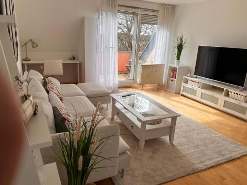uma sala de estar com um sofá branco e uma televisão em moderne 2-Zimmer Wohnung in Rastatt em Rastatt