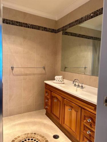 a bathroom with a sink and a mirror at Kiama Ocean Retreat in Kiama