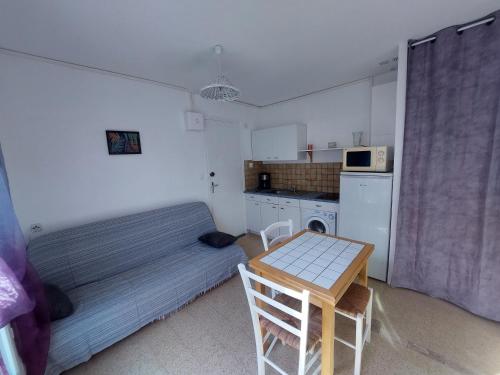 Cette petite chambre comprend un lit et une table. dans l'établissement Appartement 1mn de la plage, à Valras-Plage
