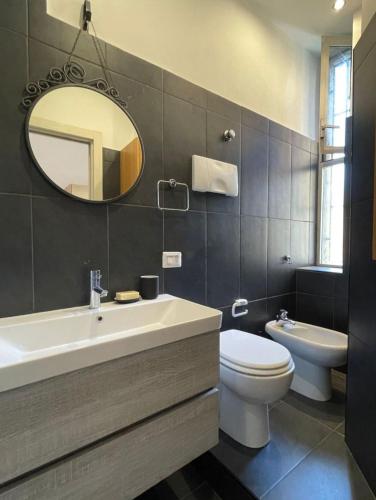 a bathroom with a sink and a toilet and a mirror at Apartment Navigli Milano in Milan