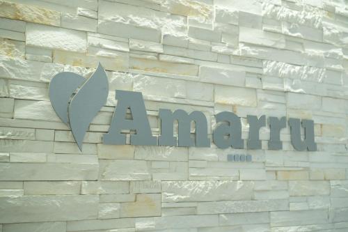 a sign for aantara on a brick wall at Amarru Apartments in Piran