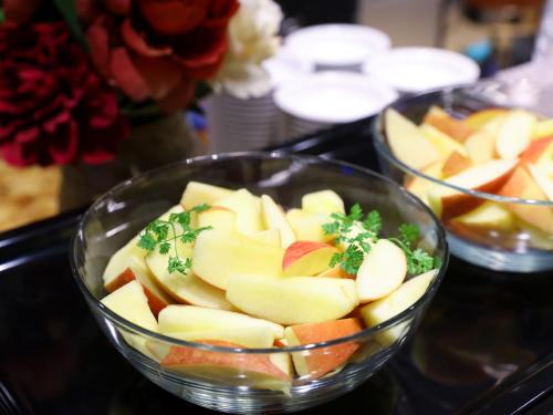 a glass bowl filled with apples on a table at Dormy Inn Kawasaki Natural Hot Spring in Kawasaki