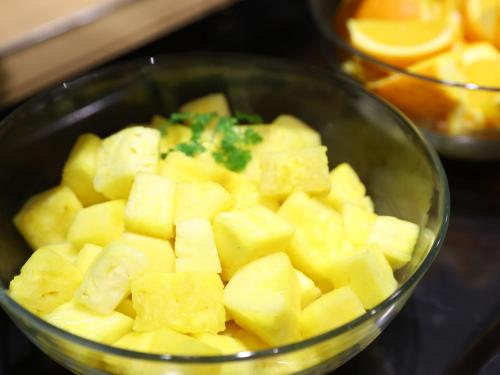 a bowl filled with cut up pineapple on a counter at Dormy Inn Kawasaki Natural Hot Spring in Kawasaki