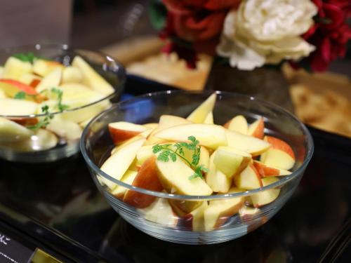 a bowl of apples and oranges on a table at Dormy Inn Kawasaki Natural Hot Spring in Kawasaki