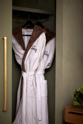 a white robe is hanging on a rack at The Jay, Autograph Collection in San Francisco