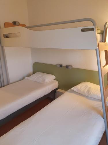 two bunk beds in a small room with at Ibis Budget Roanne Hôtel in Roanne