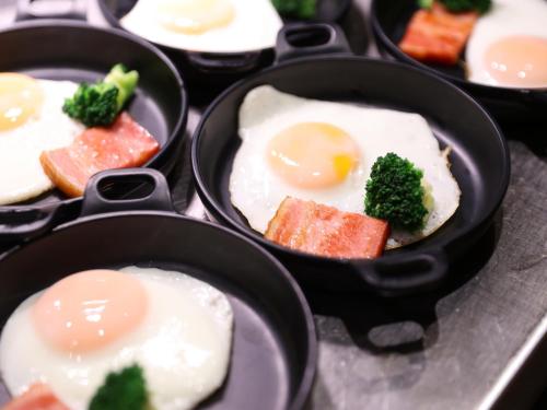 a group of pans filled with eggs and broccoli at Dormy Inn Kawasaki Natural Hot Spring in Kawasaki